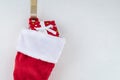 Close up of traditional red and white plush Christmas stocking stuffed with wrapped present Royalty Free Stock Photo