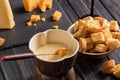 Close up. Traditional Swiss cheese fondue. Crouton dipped into hot fondue with gruyere on a long-stemmed fork. Royalty Free Stock Photo