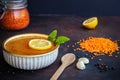 Close up of traditional turkish lentil soup with lemon and mint in ceramic bowl, glass jar with red lentils, lemon, black Royalty Free Stock Photo