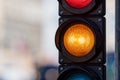 Close-up of traffic semaphore with orange light on defocused city street background with copy space Royalty Free Stock Photo