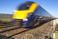 Close up of train speeding through English countryside on bright Royalty Free Stock Photo