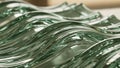 Close-up of translucent wavy glass surfaces with green and blue reflections and soft focus Royalty Free Stock Photo
