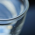 Close-up of a transparent glass cup filled with liquid, possibly water. The surface Royalty Free Stock Photo