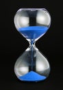 Close-up of a transparent hourglass with blue sand Royalty Free Stock Photo