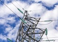 Close up of a transparent turquoise high voltage insulator or isolator in sunlight on electric tower on blue sky background Royalty Free Stock Photo