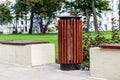 Close-up of trash cans and benches. City bench made of wood on a cement base in the Park. Space for lettering or design