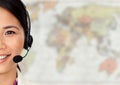 Close up of travel agent with headset against blurry map Royalty Free Stock Photo