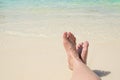 Close up traveler cross barefoot leg laying on beach at sea shore,Relaxing in summer vacation time