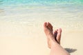 Close up traveler cross barefoot leg laying on beach at sea shore,Relaxing in summer vacation time