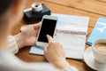 Close up of traveler hands with smartphone and map Royalty Free Stock Photo