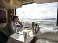 CLOSE UP: Traveler lies in her bed and observes the lake through the window.