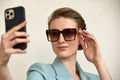 Close-up of trendy girl face in sunglasses is making selfie photo. Royalty Free Stock Photo