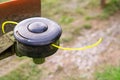 Close-up of the trimmer. Nylon yellow grass trimmer string and head. The coil of a manual lawn mower. A tool for cleaning the terr