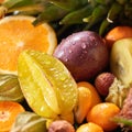 Close-up tropical background with fresh helthy fruits carambola, passion fruit, orange, kumquat.