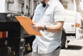 Close up a truck driver holding clipboard inspecting safety check a truck