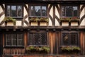 a close-up of a tudor houses ornate wooden window frames and brickwork