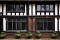 a close-up of a tudor houses ornate wooden window frames and brickwork