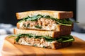 close up of a tuna sandwich with lettuce on sourdough bread