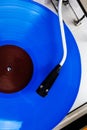 Close up of turntable needle on a blue vinyl