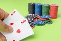 close-up of two aces held in one hand on the green game mat on the right side of the image to leave room for editing, other cards Royalty Free Stock Photo