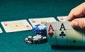 close-up of two aces held in one hand on the green game mat on the right side of the image to leave room for editing, other cards Royalty Free Stock Photo