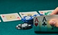 close-up of two aces held in one hand on the green game mat on the right side of the image to leave room for editing, other cards Royalty Free Stock Photo