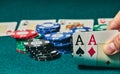 close-up of two aces held in one hand on the green game mat on the right side of the image to leave room for editing, other cards Royalty Free Stock Photo