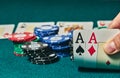 close-up of two aces held in one hand on the green game mat on the right side of the image to leave room for editing, other cards Royalty Free Stock Photo