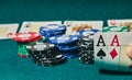 close-up of two aces held in one hand on the green game mat on the right side of the image to leave room for editing, other cards Royalty Free Stock Photo