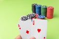 close-up of two aces held in one hand on the green game mat on the right side of the image to leave room for editing, other cards Royalty Free Stock Photo