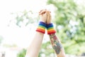 Two women`s hands in the air wearing gay rainbow wristbands Royalty Free Stock Photo