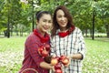 Asia woman farmer family holding red Apples and present product at public park. Royalty Free Stock Photo