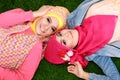 Close up of two beautiful happy muslim woman lying on grass Royalty Free Stock Photo