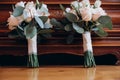 Close up of two beautiful modern and stylish wedding bouquet of white, pink roses and eucalyptus greenery on wooden background. Royalty Free Stock Photo