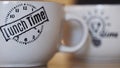 Close up of two big white mugs with lunch time inscription and a light bulb image. Concept. Beautiful tea or coffee mugs Royalty Free Stock Photo