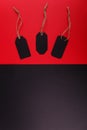 Black tags on a bright red background. The black background is empty. Royalty Free Stock Photo