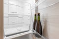 Close-up of two bottles standing in a refrigerator on a door shelf in an empty refrigerator. The concept of alcoholic Royalty Free Stock Photo