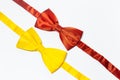 Close-up of two bow ties of red and yellow colors isolated on white background. Royalty Free Stock Photo