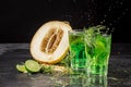 Close-up of two bright tarragon splashing cocktails on a black background. Drinks with tarragon, sweet cut melon, ice cubes, and Royalty Free Stock Photo