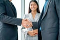 Close up two business man shake hands together in front of business woman with smiling show success of cooperation together in the Royalty Free Stock Photo