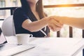 Close-up of two business people women shaking hands at the working place.