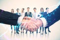 Close up of two businessmen shaking hands with their diverse blurry colleagues in the background. Concept of business partnership Royalty Free Stock Photo