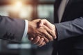 Close-up of two businesspeople shaking hands in office. Colleagues greeting each other with handshake, handshaking close up, to