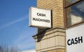 Close up of two cash signs placed on a British building very close to each other.