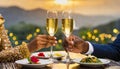 close-up of two champagne glasses and a couple\'s hands on a restaurant table. a romantic pair