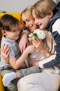 Close-up of two cheerful little funny kid child sons congratulating happy young mom with mothers day presenting bouqert Royalty Free Stock Photo