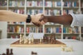 Close up of two chess players shaking hands over chess board after match Royalty Free Stock Photo