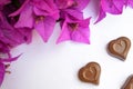 Close-up of two chocolate hearts and pink Bougainvillea flowers