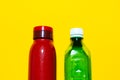 Close-up of two closed bottles. Reusable steel thermo water bottle of red color and disposable plastic bottle of green. Royalty Free Stock Photo