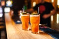 Close-up of two colorful orange cocktails with lime and brown sugar in bar, blurred background. Royalty Free Stock Photo